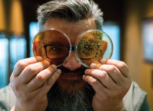 Karl De Smedt looking through petri dishes containing yeast that goes into sourdough samples