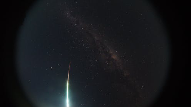 A meteorite streak through the dark sky with the milky way in the background